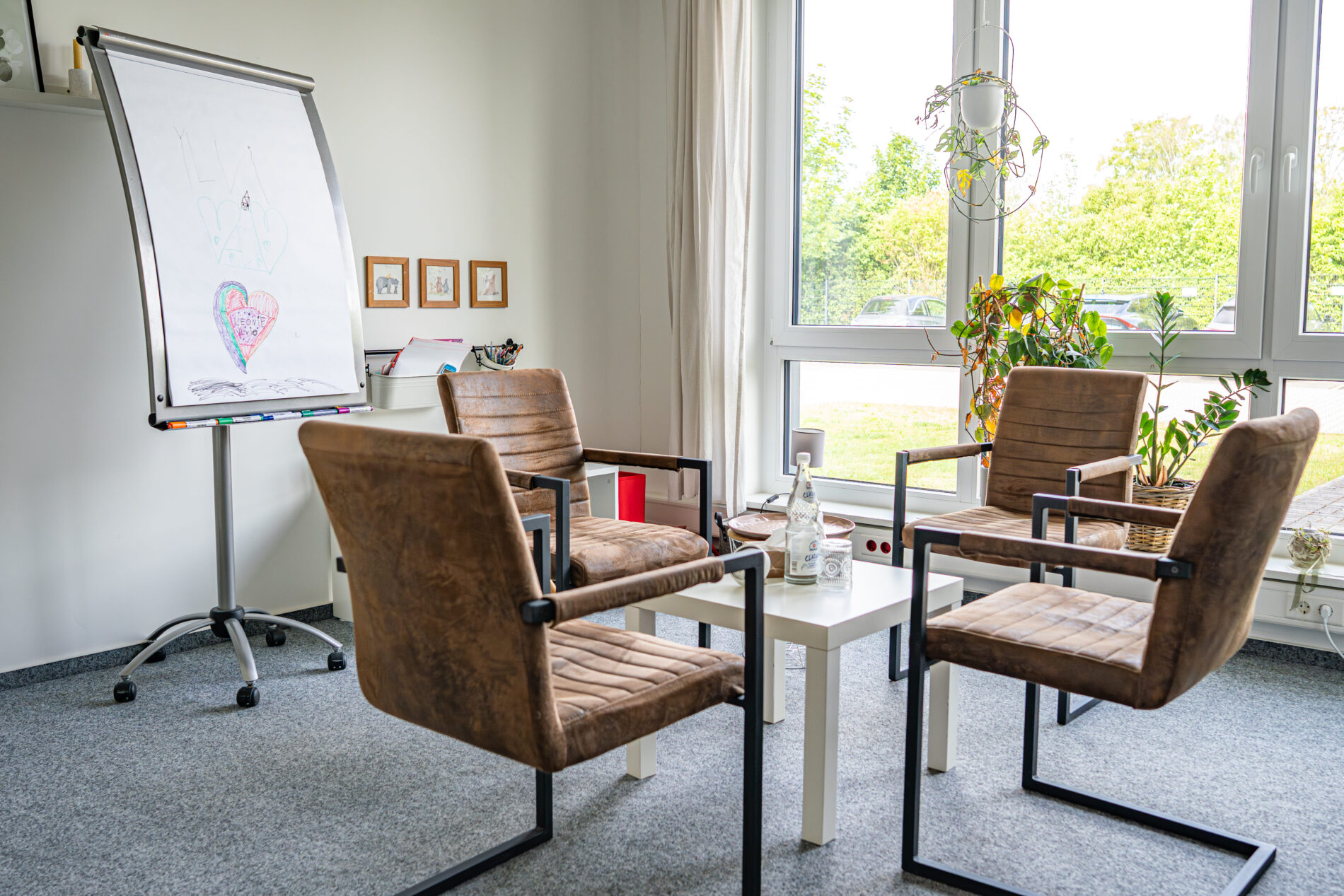 Beratungsraum der JUNA GbR in Herten mit braunen Sesseln und Flipchart für systemische Familientherapie und Jugendhilfe — Praxis nach SGB VIII