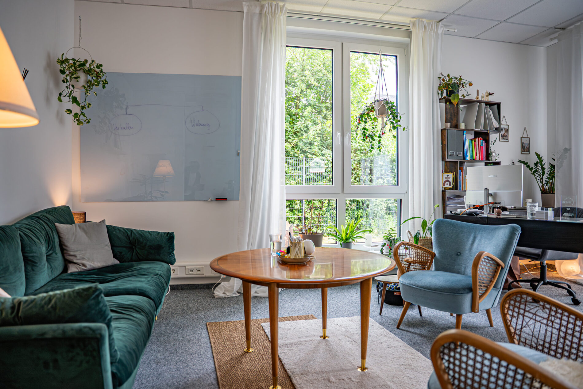 Therapieraum der JUNA GbR Herten mit grüner Couch, Whiteboard und Genogramm-Skizze — systemische Familientherapie und Biografiearbeit in Herten
